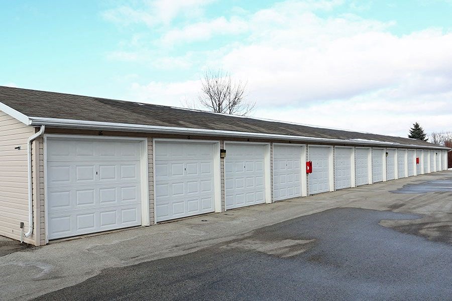 a row of white garage doors on the side of a building