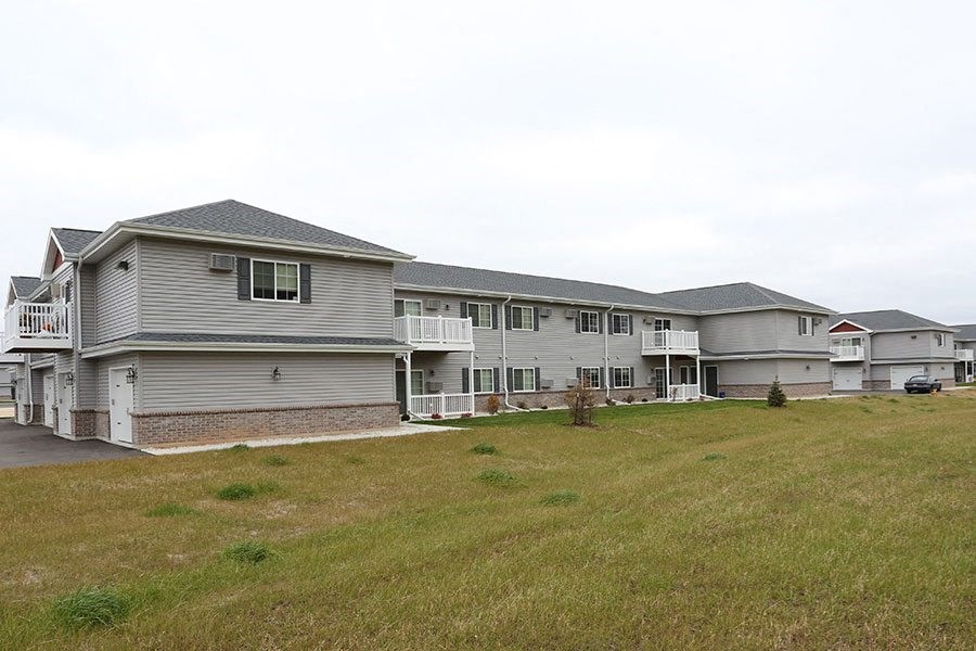a row of houses on a hill next to a field