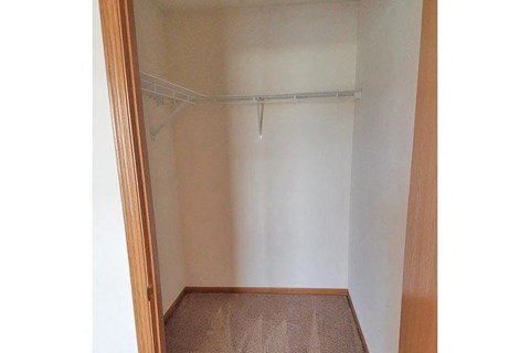 a empty closet with a white wall and a door