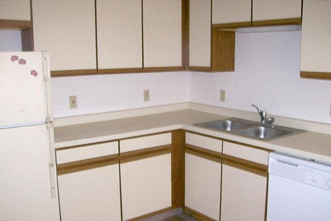 an empty kitchen with white cabinets and a sink