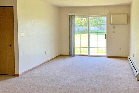 an empty living room with a sliding glass door