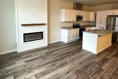 A kitchen with a white oven and wooden flooring.