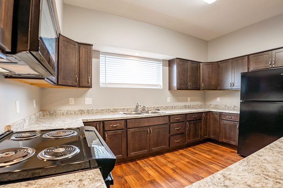 A kitchen with wooden cabinets and a black stove top oven.