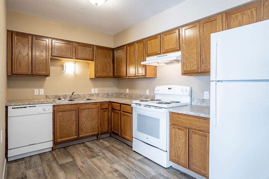 a kitchen with white appliances and wooden cabinets