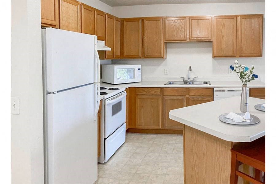 a kitchen with white appliances and wooden cabinets