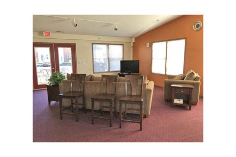 A room with orange walls and a television on the wall.