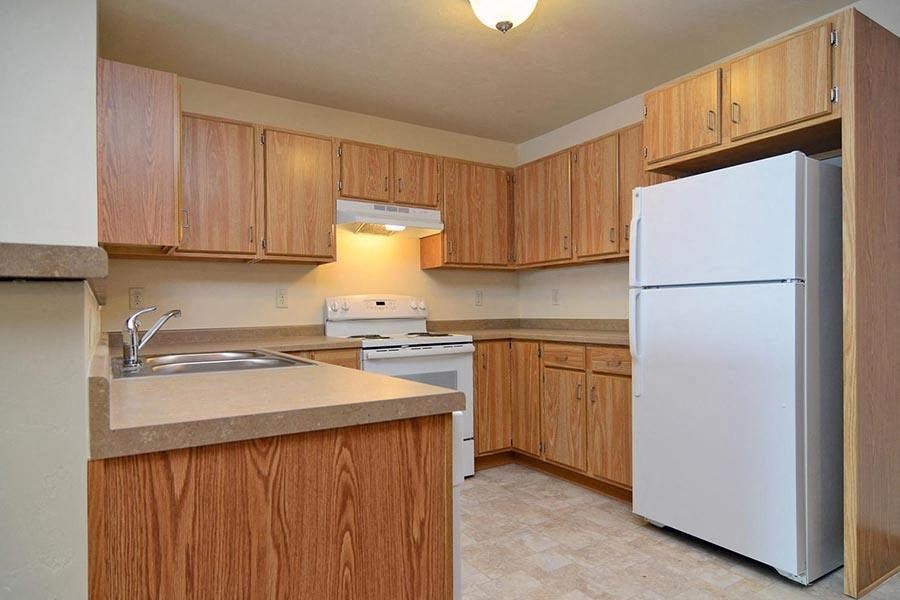 A kitchen with wooden cabinets and a white refrigerator.