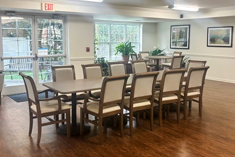 A conference room with a table and chairs and an exit sign above it.