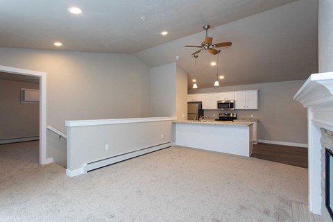 A spacious living room with a fireplace on the right side.