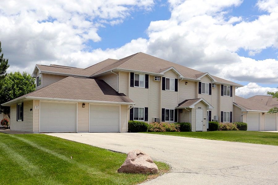 A large house with a driveway in front.