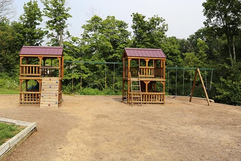 a playground with two wooden structures   and trees