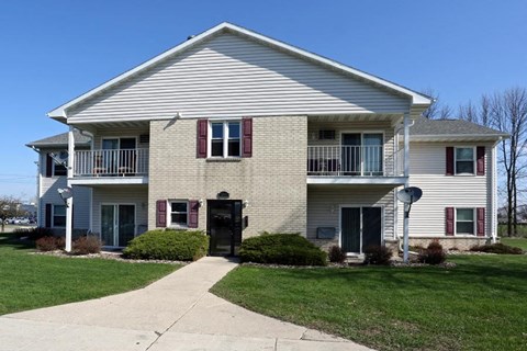A two-story house with a white exterior and red shutters.