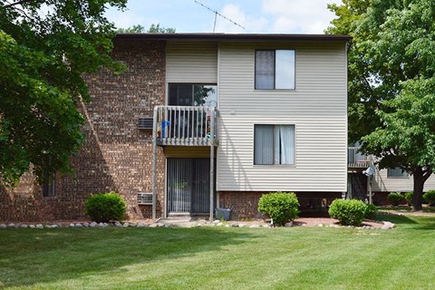 A two-story residential building with a balcony on the second floor.