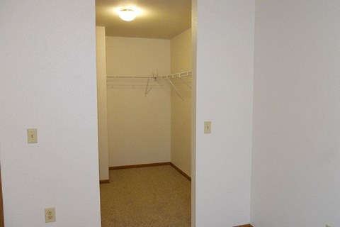 A white wall with a light switch and a white door.