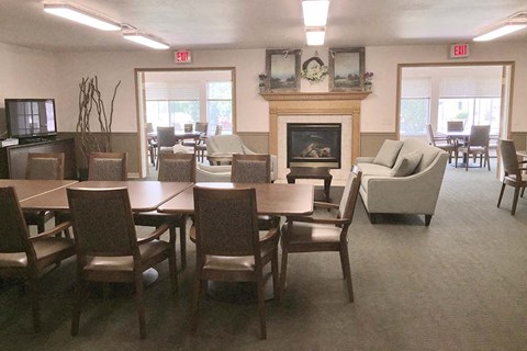 A room with a fireplace, chairs, and a television.