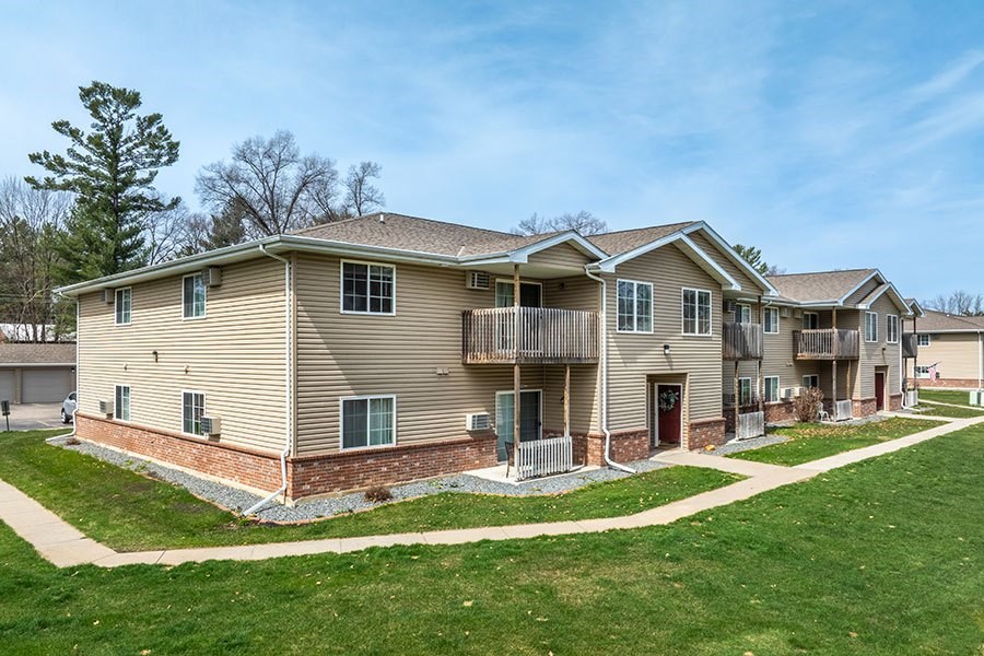 A row of houses with a green lawn in front.