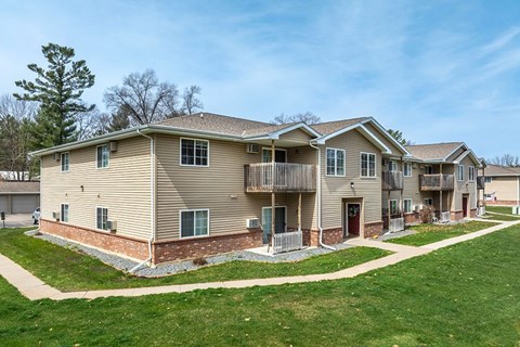A row of houses with a green lawn in front.