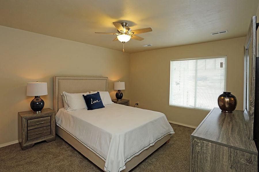 a bedroom with a bed and a ceiling fan