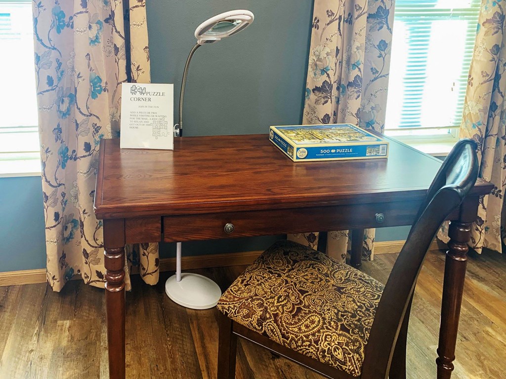 a desk with a book and a chair in a room