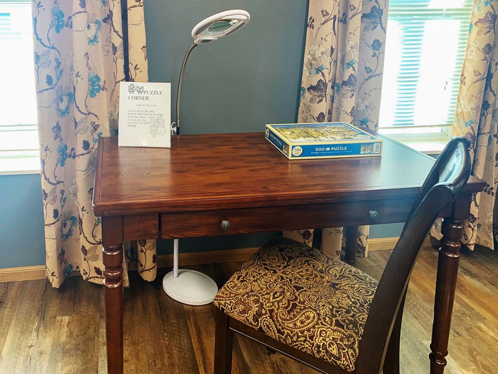 a desk with a book and a chair in a room