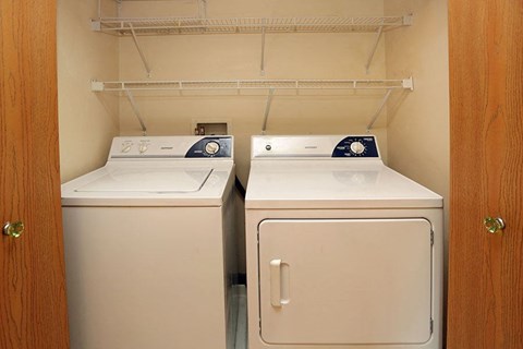 two washing machines in a room with a closet