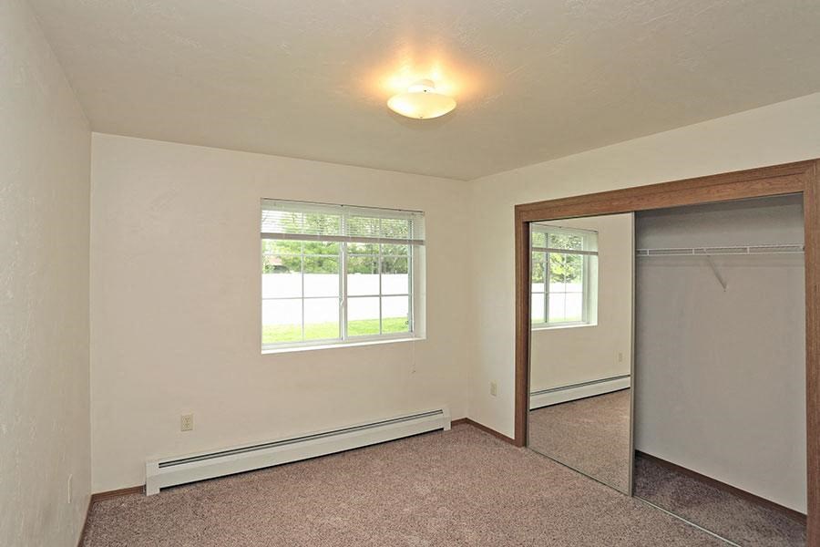 an empty room with a window and a closet