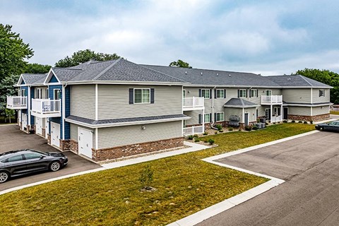 a row of houses with cars parked in a parking lot