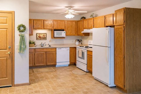 A kitchen with wooden cabinets and white appliances.