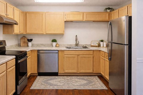 A kitchen with wooden cabinets and a stainless steel refrigerator.