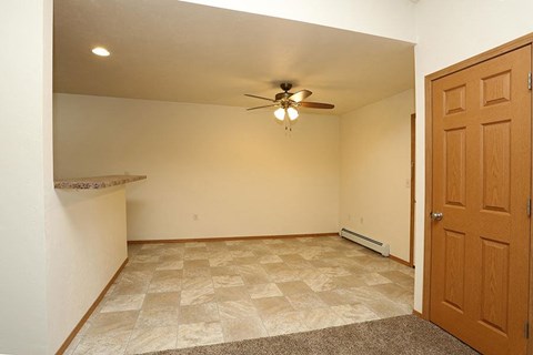 a empty room with a ceiling fan and a door