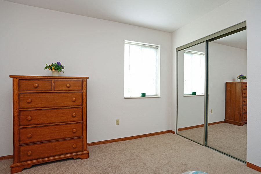 a bedroom with a dresser and a mirror