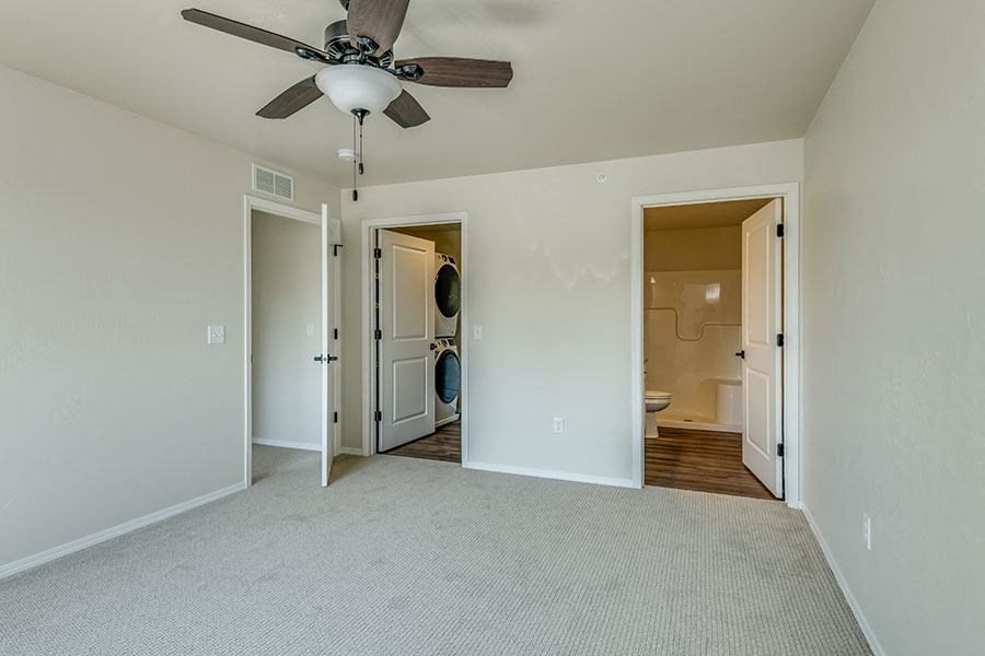 an empty living room with a ceiling fan