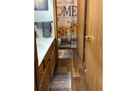 A bathroom with a wooden door and a sign that says "some sunflowers ME".