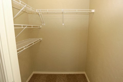 a empty walk in closet with empty shelves