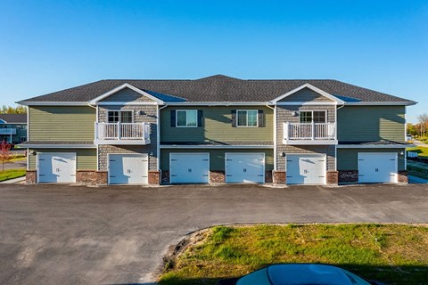 a house with blue garage doors and a car parked in front of it