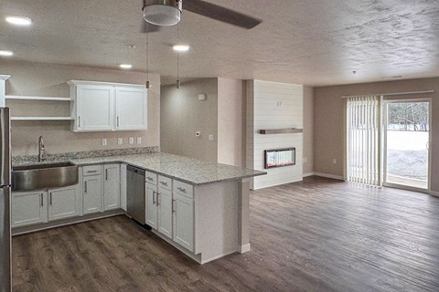 A kitchen with white cabinets and a wooden floor.