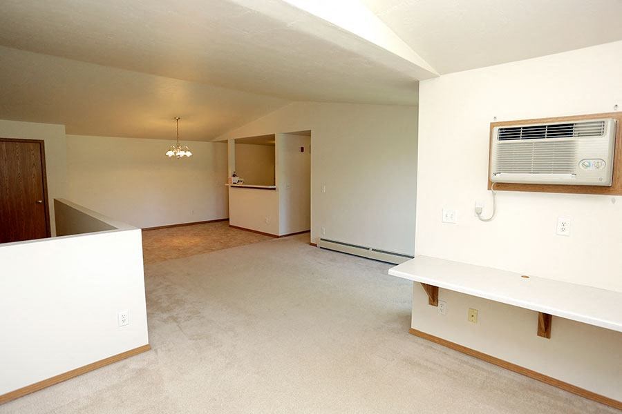 an empty living room with an air conditioner in it