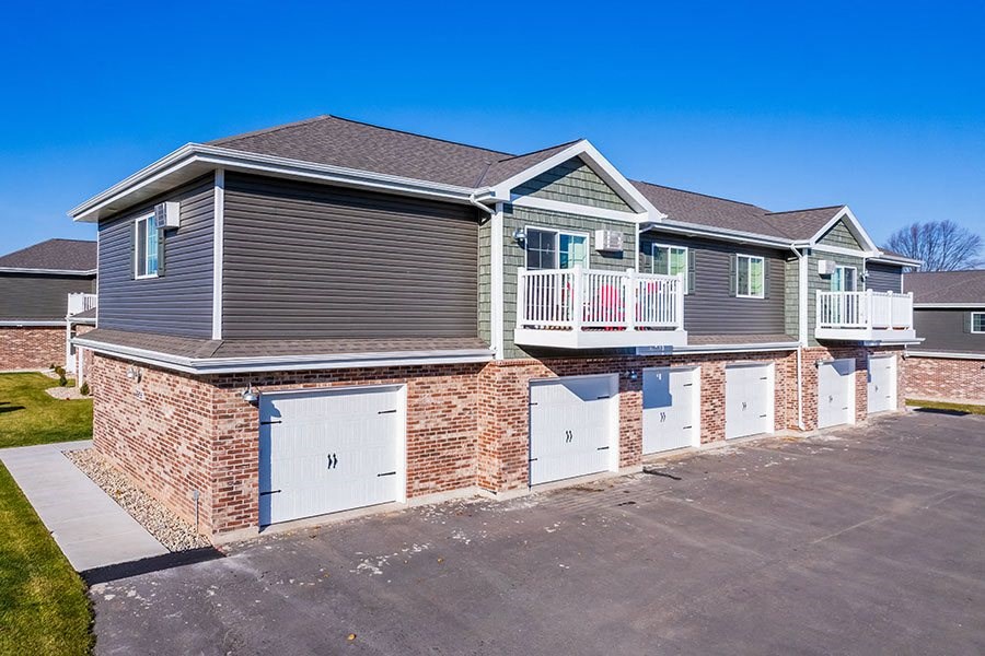 a brick house with a garage and a balcony