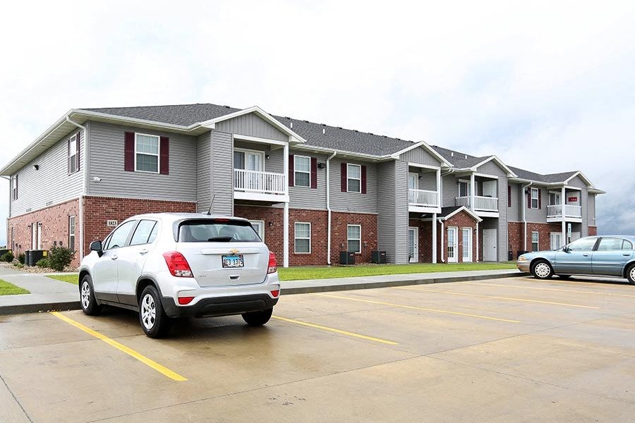 a car parked in a parking lot in front of an apartment building