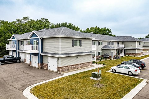 a row of houses with cars parked in a parking lot