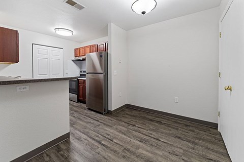 A kitchen with a refrigerator and microwave.