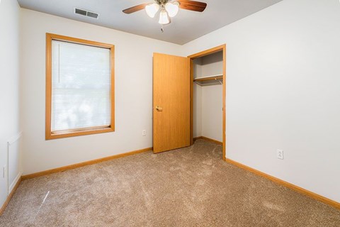 A room with a ceiling fan and a door.