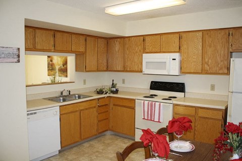 a kitchen with white appliances and wooden cabinets