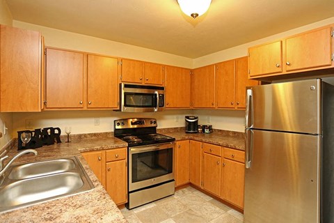 a kitchen with stainless steel appliances and wooden cabinets