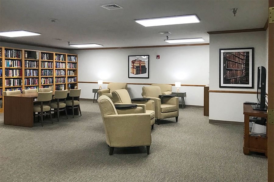 a living room with chairs and a table in a library