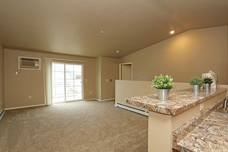 a large living room with a counter and a door