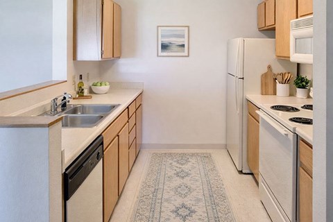 A kitchen with a white fridge, microwave, and stove.
