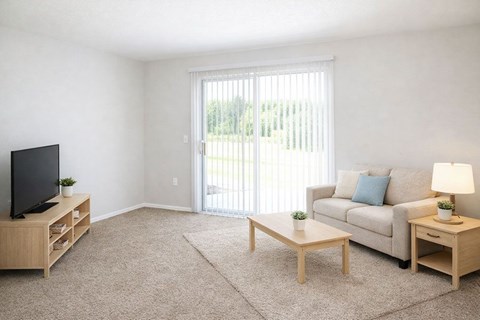 A living room with a couch, a coffee table, a television, and a lamp.