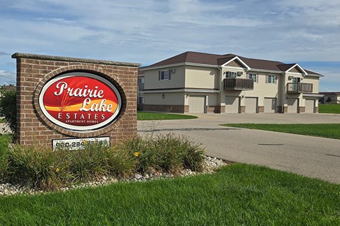 A sign for Prairie Lake Estates in front of a building.
