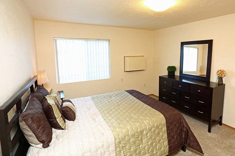 a bedroom with a large bed and a dresser